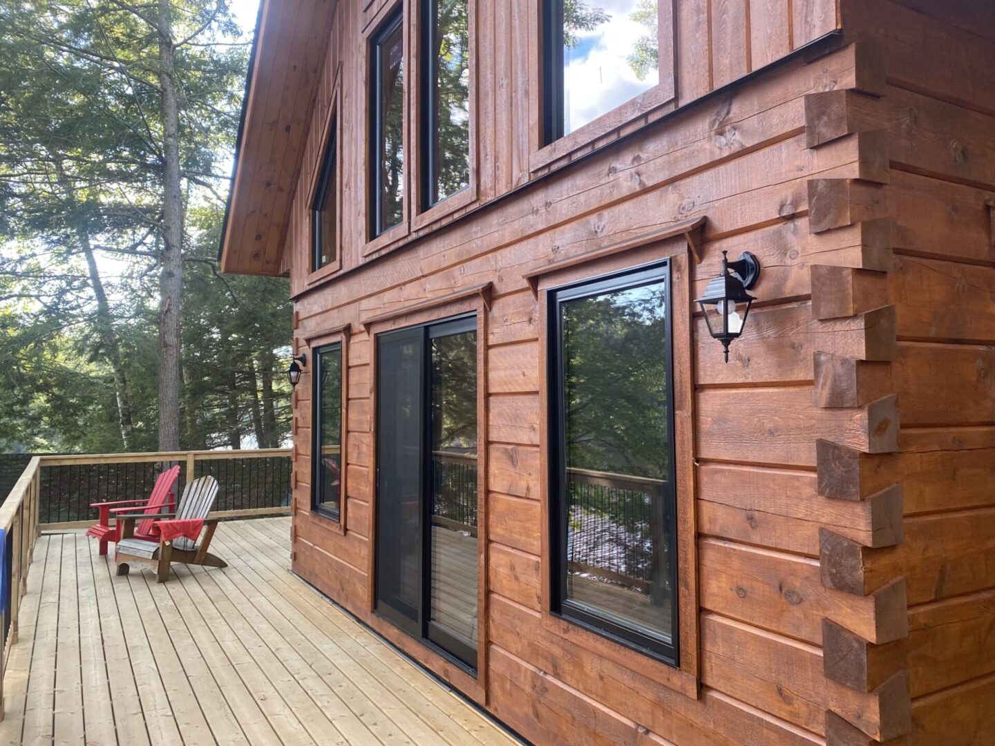 A wooden house with two windows and a deck.