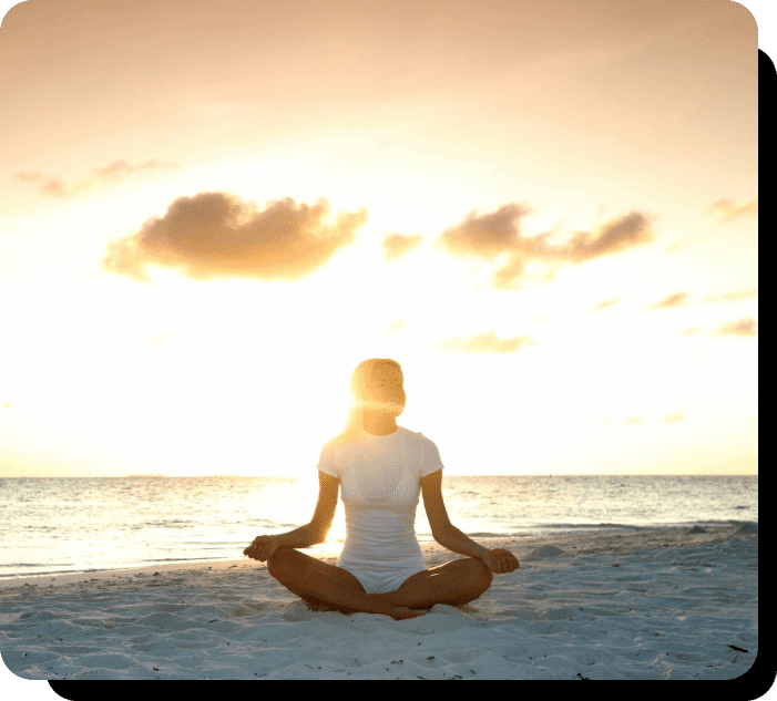 A person sitting in the sand on top of a beach.