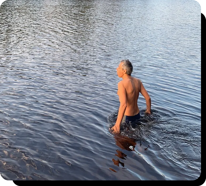 A man in the water with no shirt on.